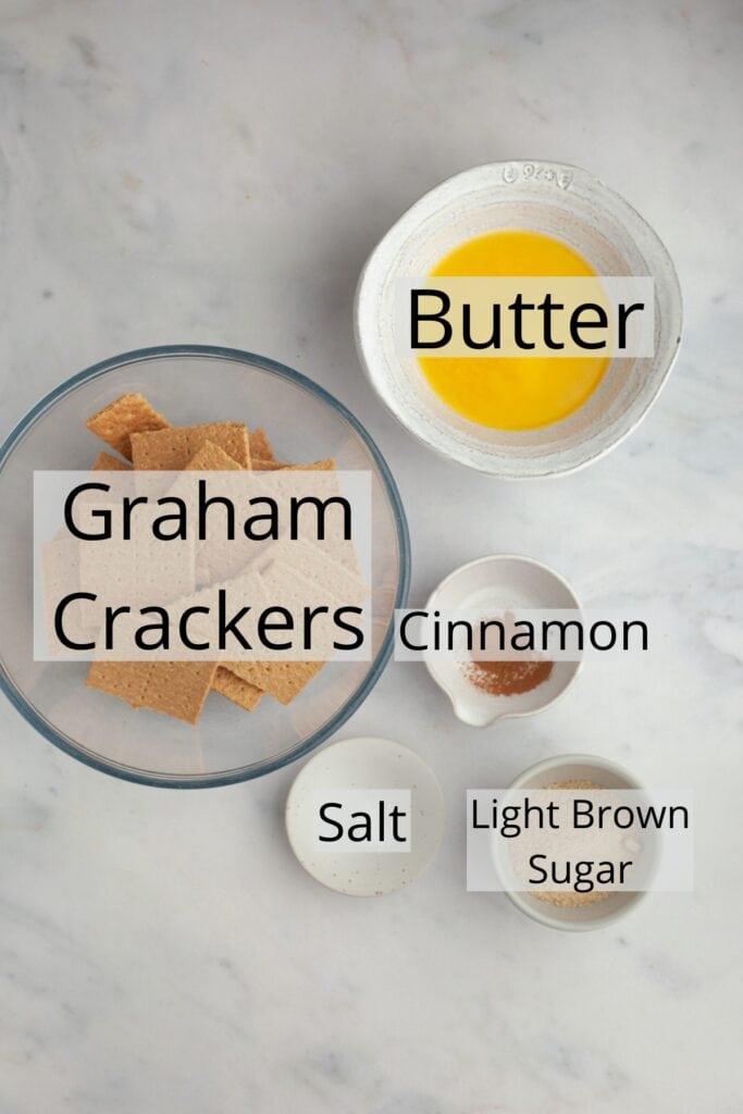 All the ingredients needed to make a graham cracker crust, weighed out into small bowls.