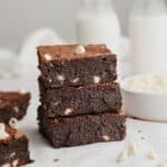 A stack of three brownies with white chocolate chips.