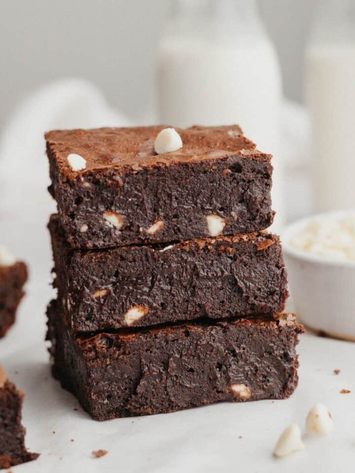 A stack of three brownies with white chocolate chips.