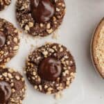 Nutella thumbprint cookies covered in chopped hazelnuts.
