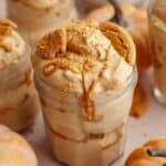 Pumpkin pie cups in mason jars, topped with crushed gingersnap cookies and drizzled cookie butter.