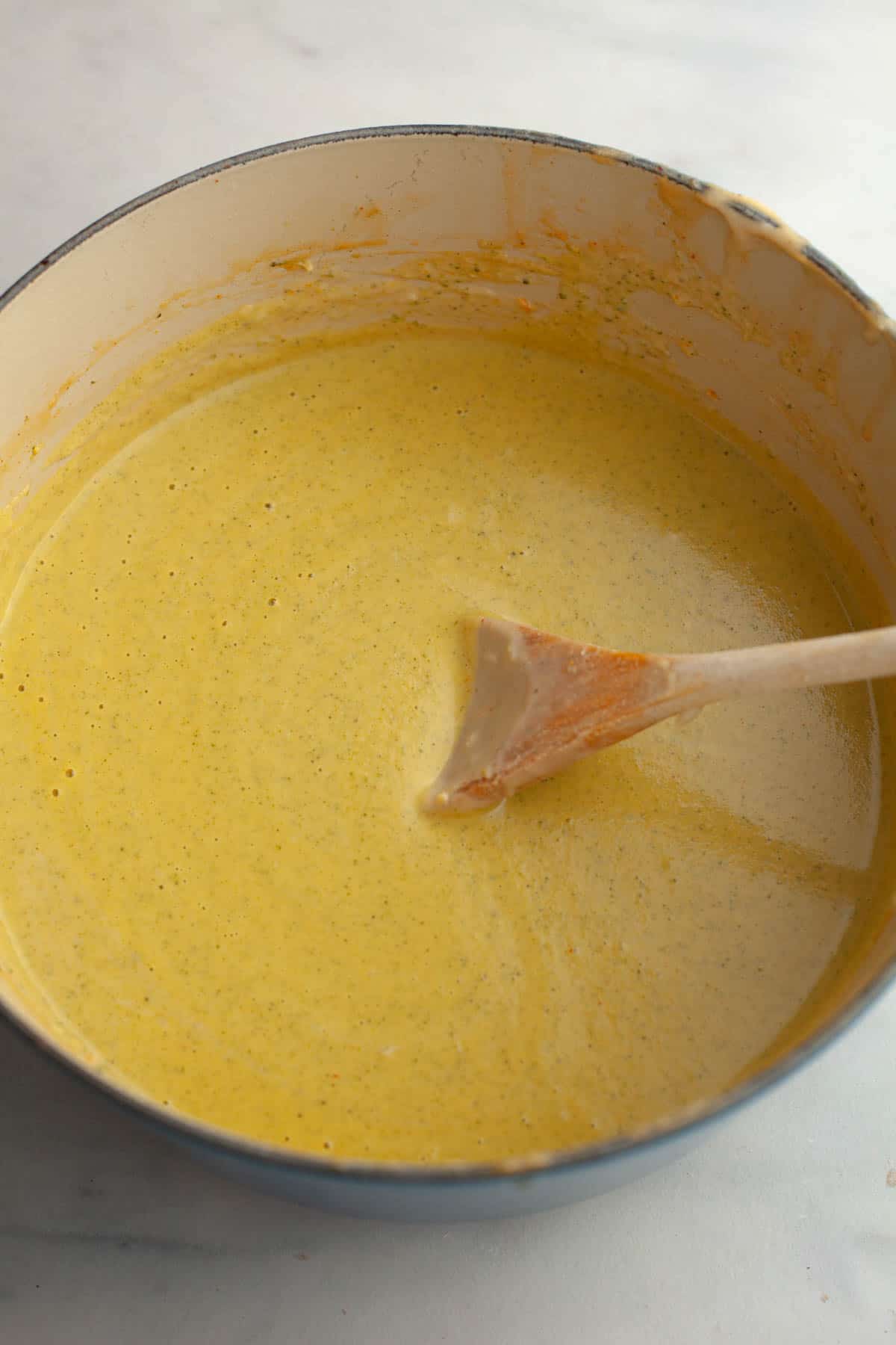 A large pot with broccoli cheddar soup and a soup.