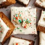 Square slices of frosted gingerbread cake with Christmas sprinkles.