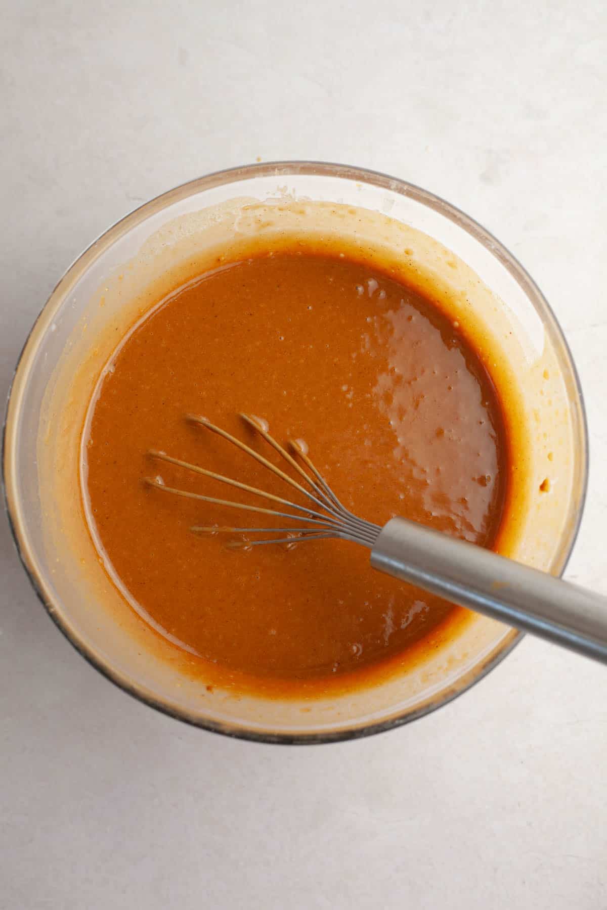 Gingerbread cake batter in a bowl with a whisk.