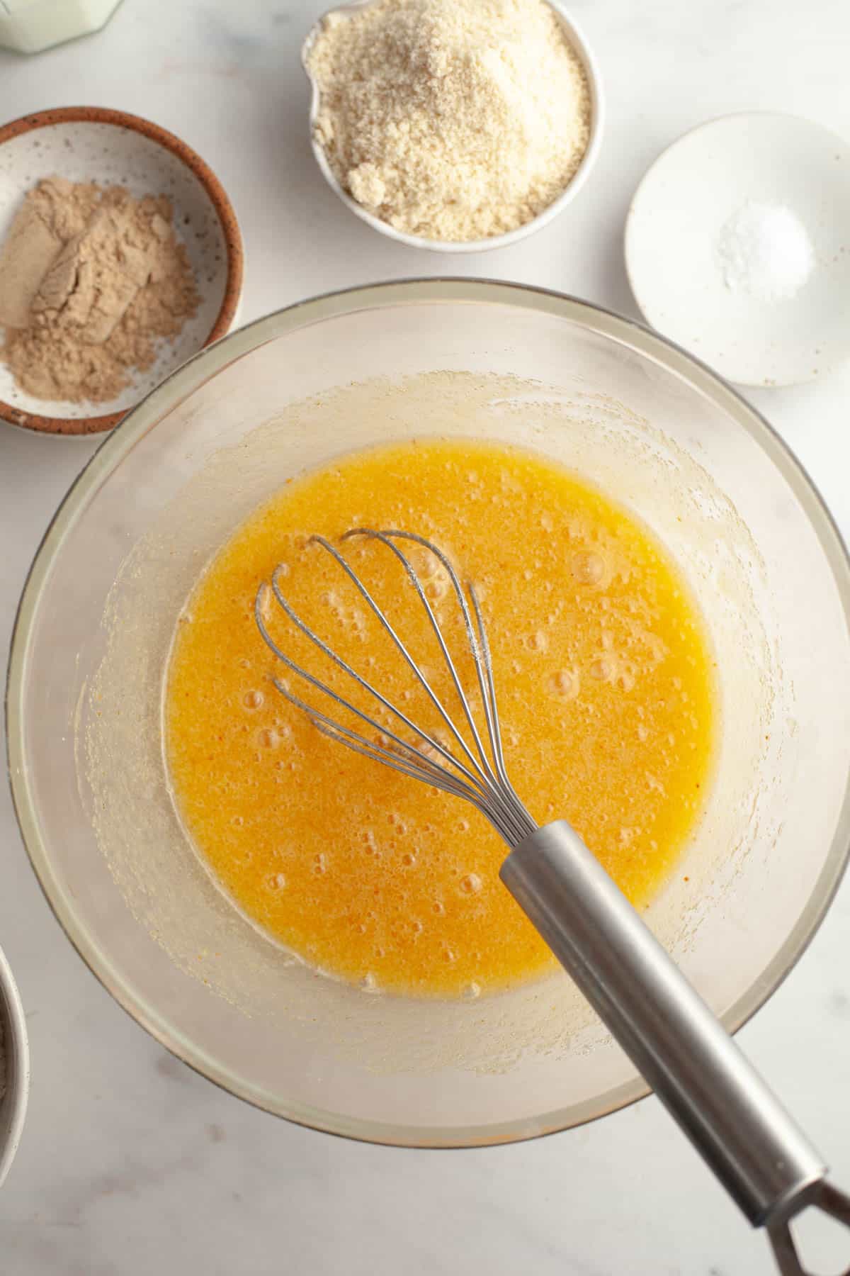 A large glass bowl with melted butter, sugar and eggs.