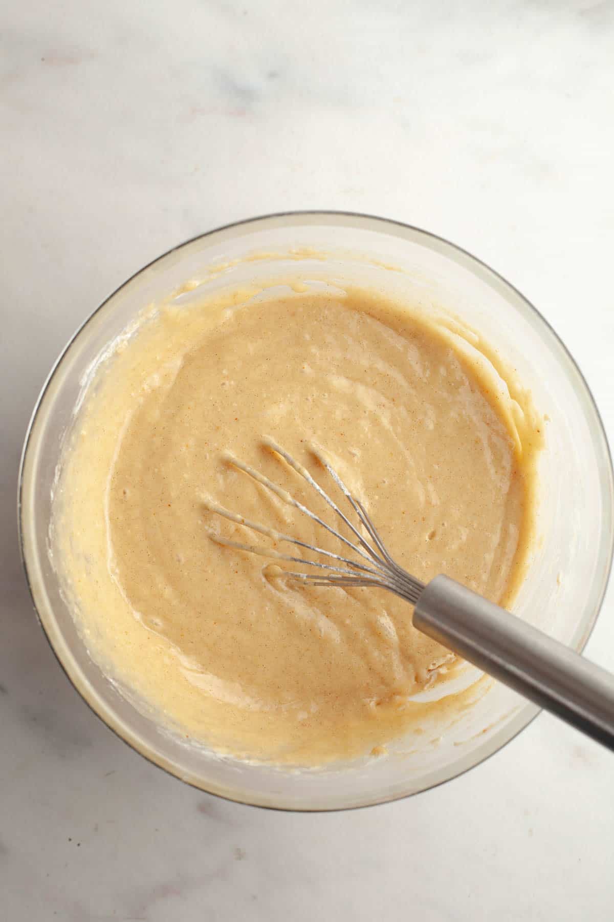 Cardamom almond cake batter in a large bowl.