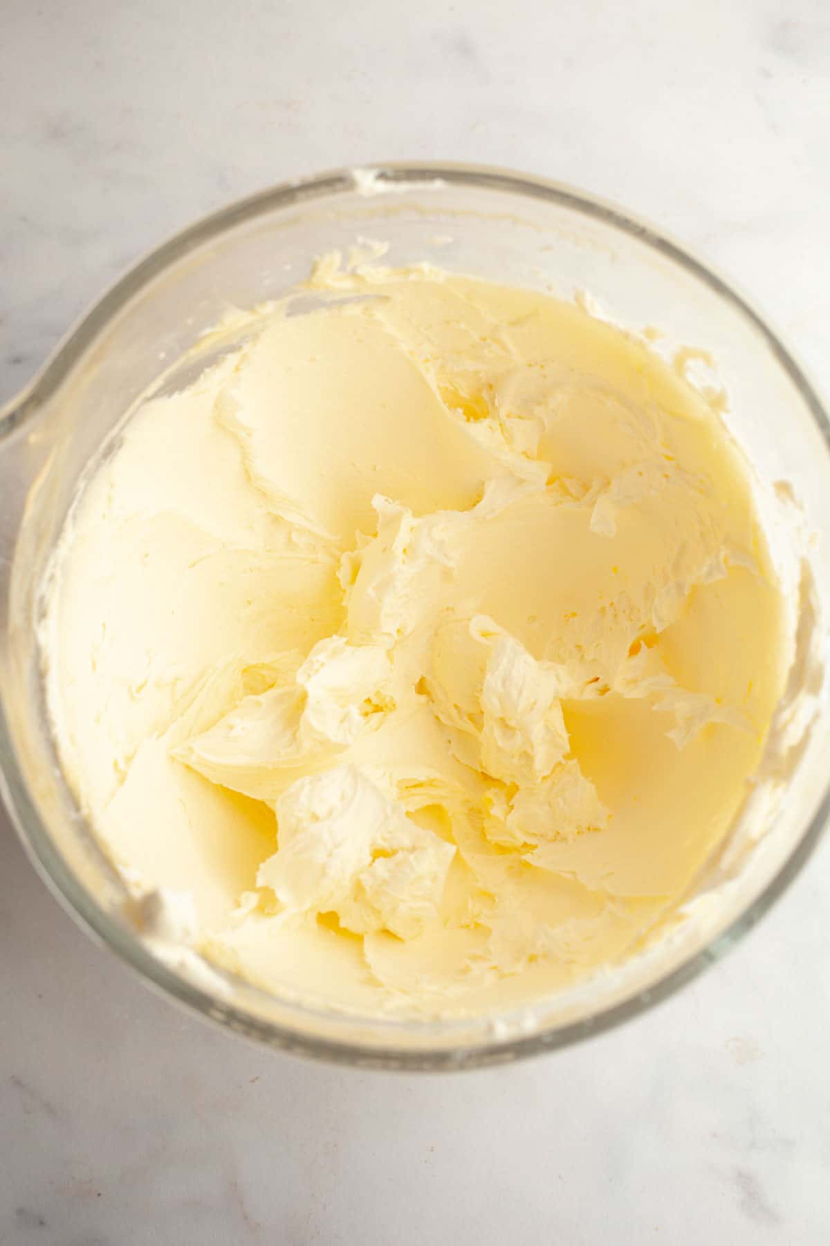 Whipped butter and powdered sugar in a glass bowl.