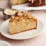 A slice of cardamom almond cake with streusel on a small plate.