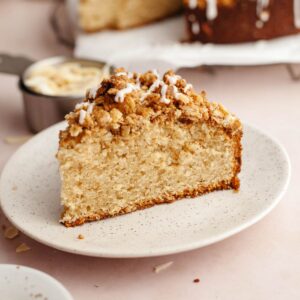 A slice of cardamom almond cake with streusel on a small plate.