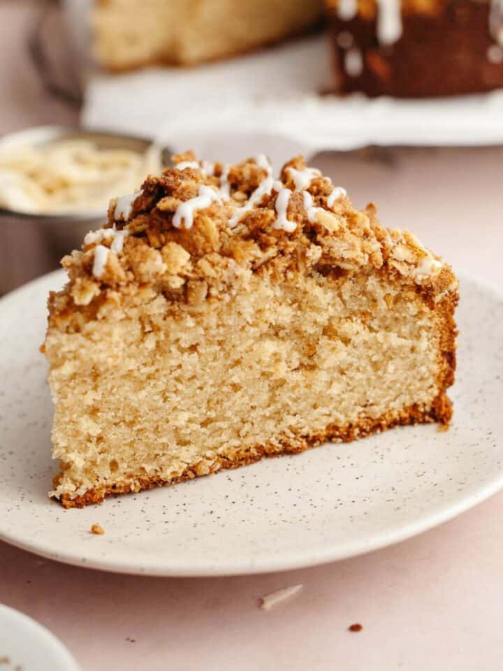 A slice of cardamom almond cake with streusel on a small plate.
