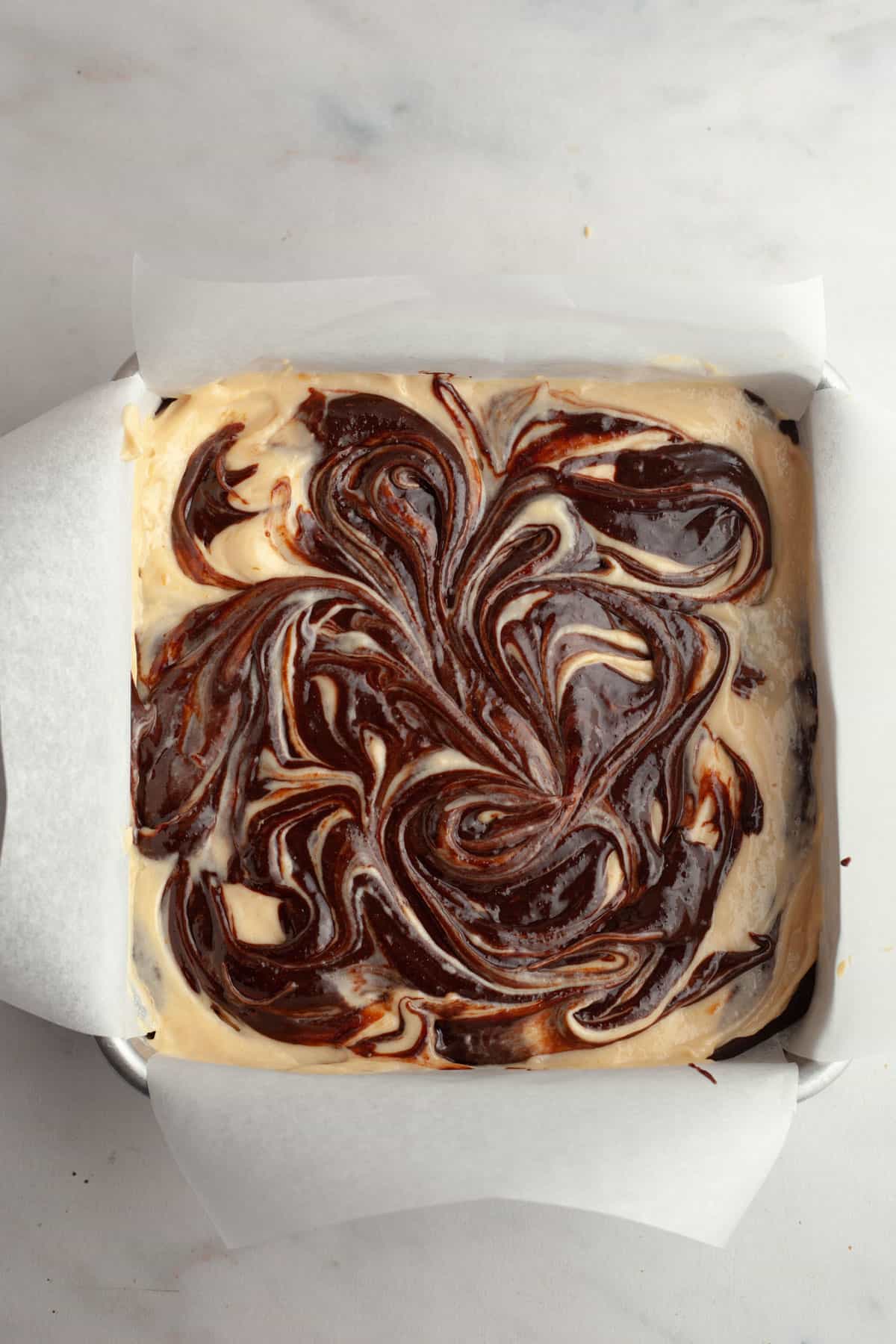 Unbaked peanut butter cream cheese brownies in a square pan.