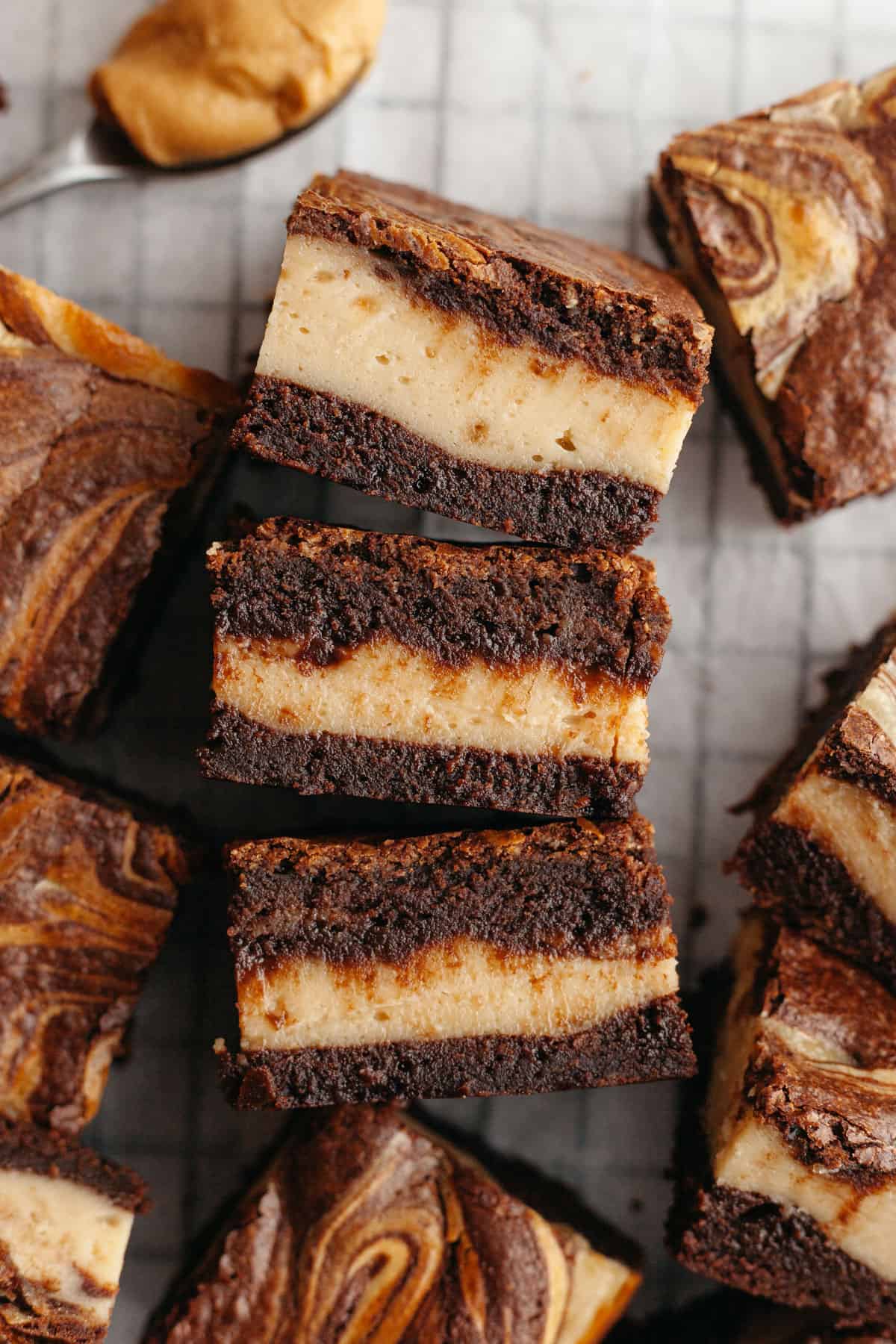 Sliced peanut butter ream cheese brownies on parchment paper.