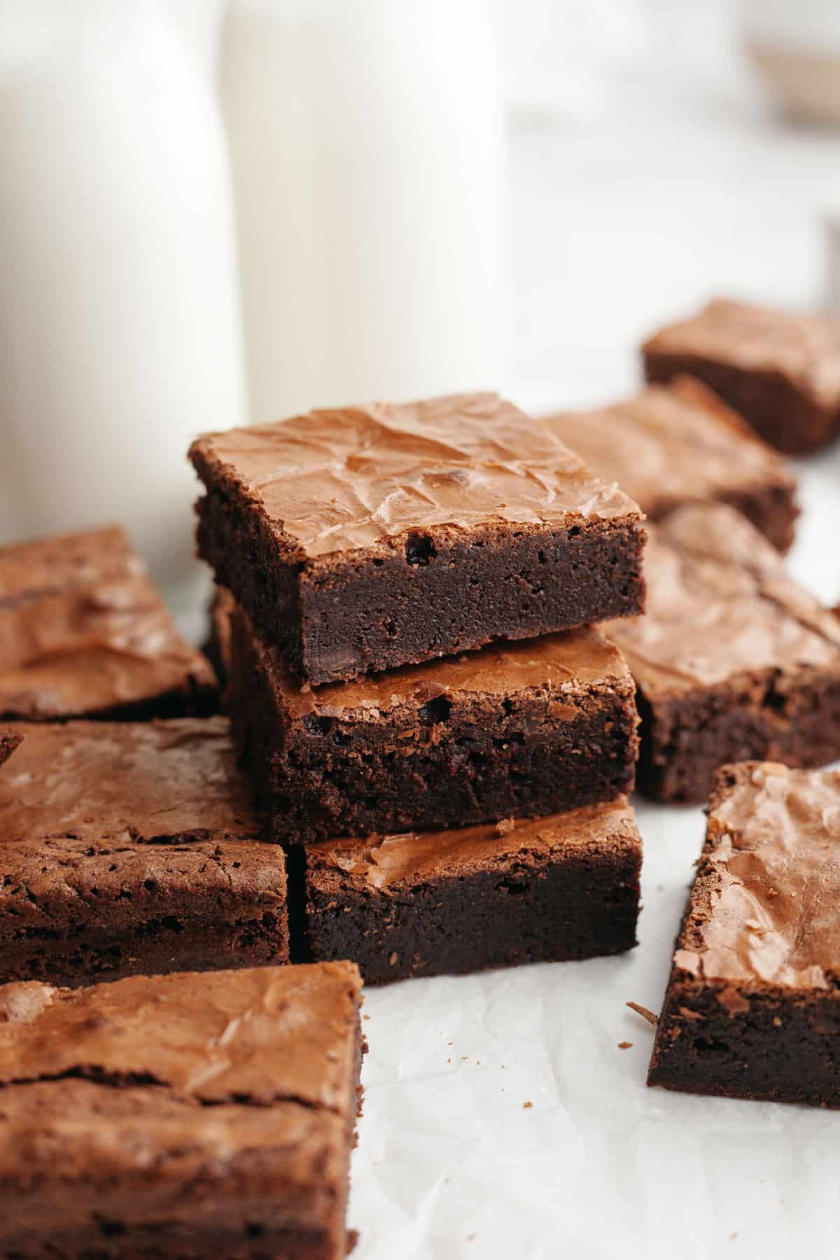 A stack of three double fudge brownies on parchment paper.