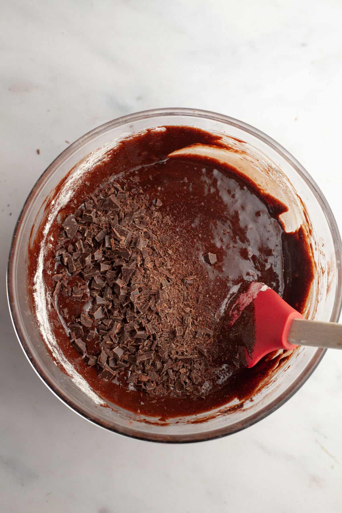 Brownie batter in a bowl with chopped chocolate.