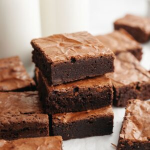 A stack of three double fudge brownies on parchment paper.