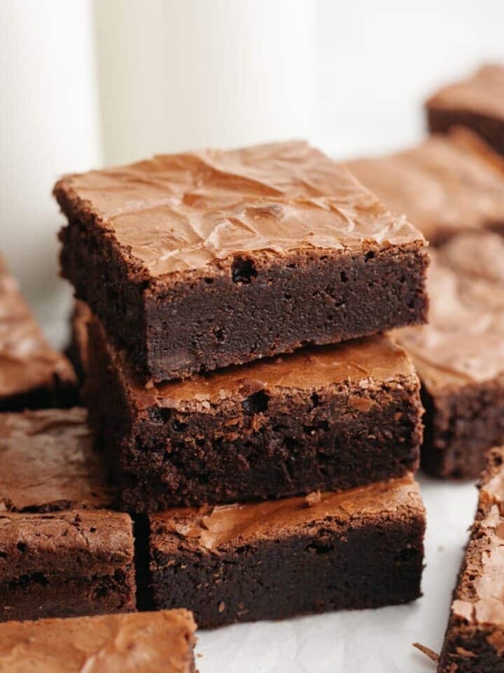 A stack of three double fudge brownies on parchment paper.