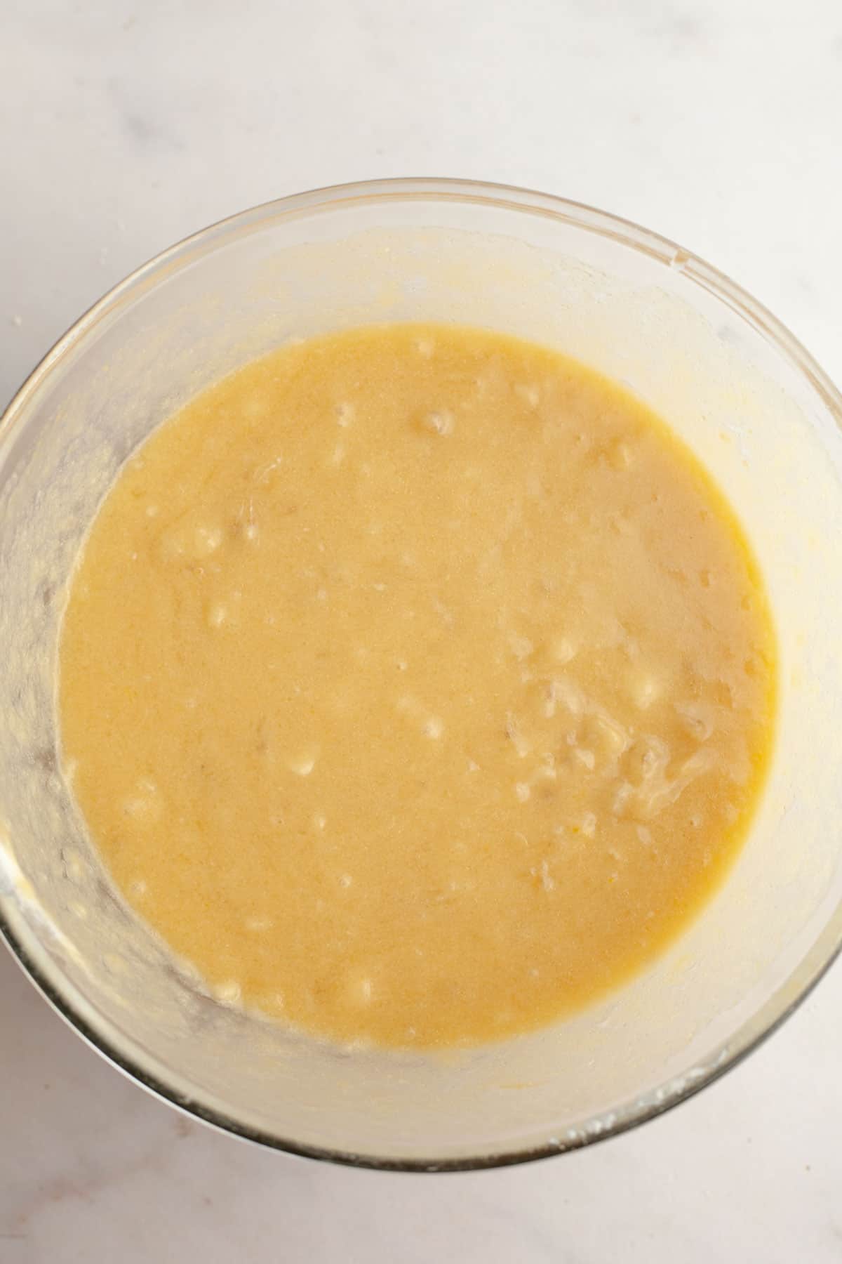 Banana muffin batter in a large glass bowl.