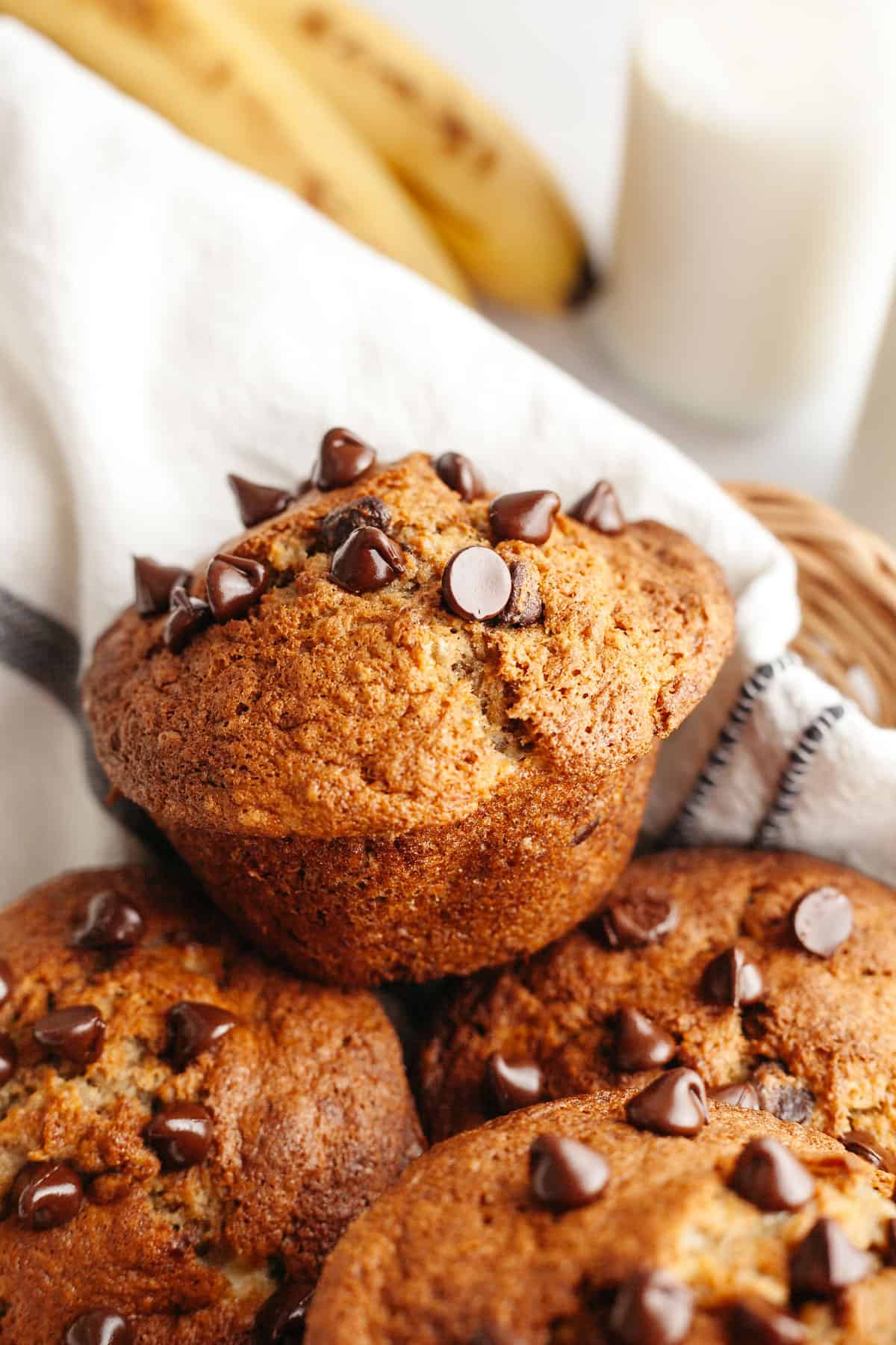 A close up of chocolate chip banana jumbo muffins in a basket.