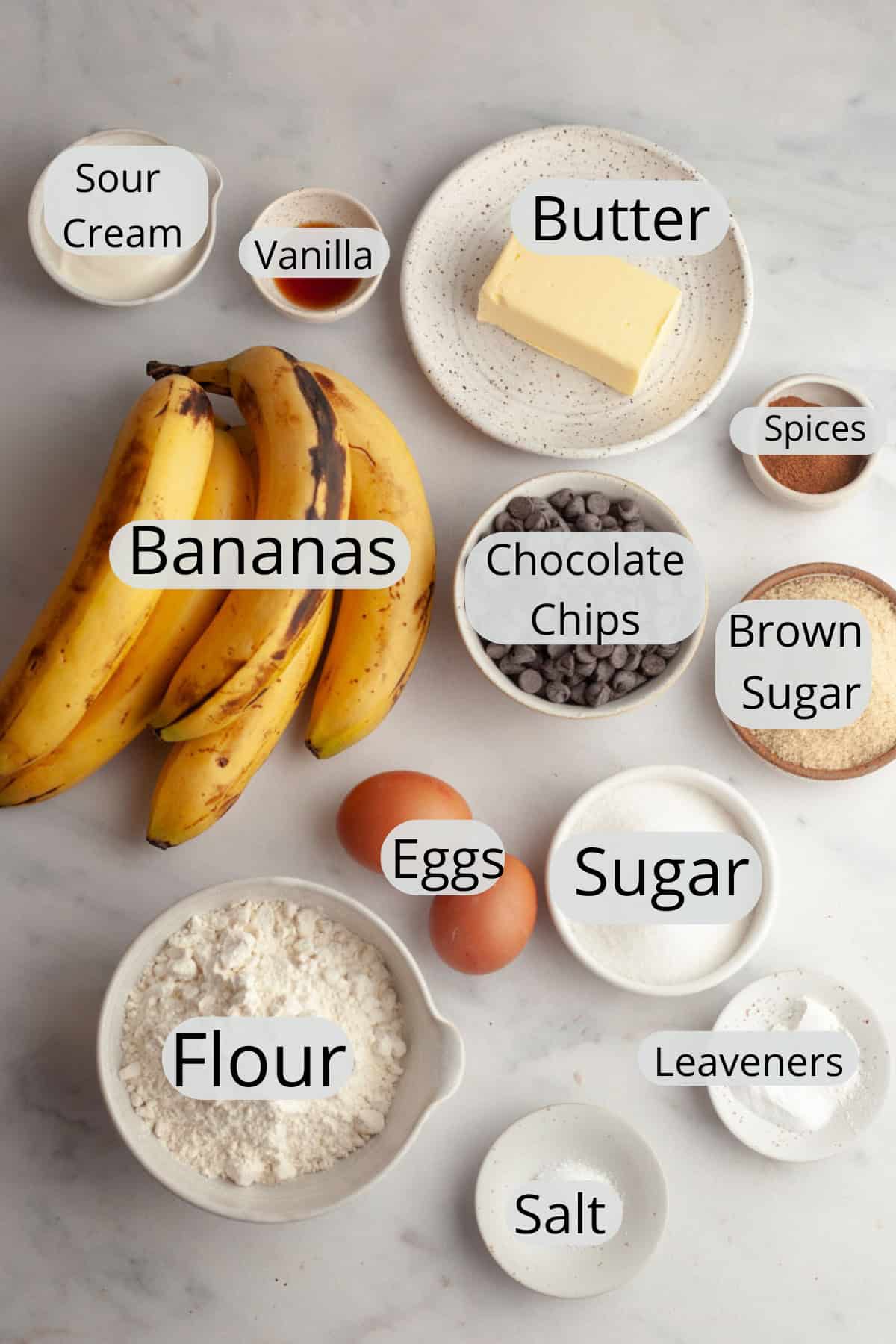All the ingredients needed to make jumbo banana muffins, weighed out into small bowls.