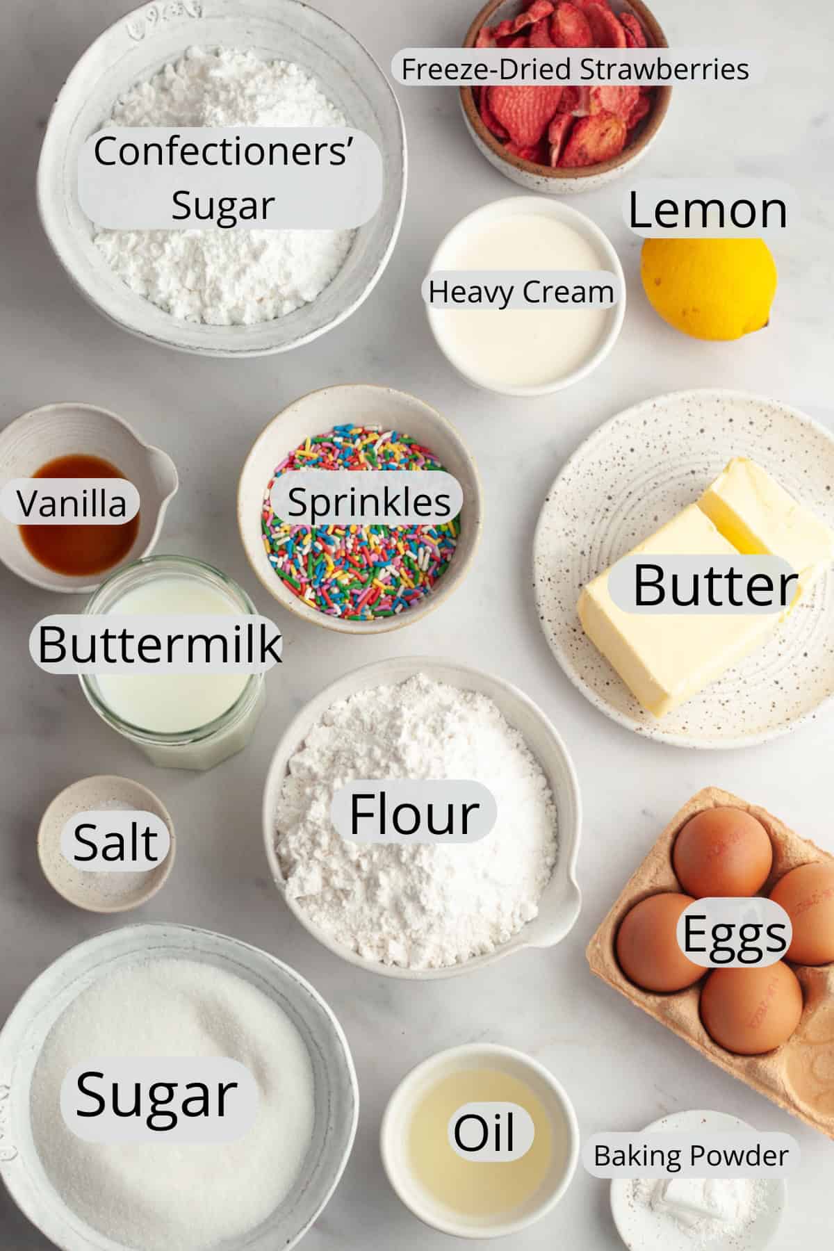 All the ingredients needed to make a strawberry funfetti cake, weighed out into small bowls.