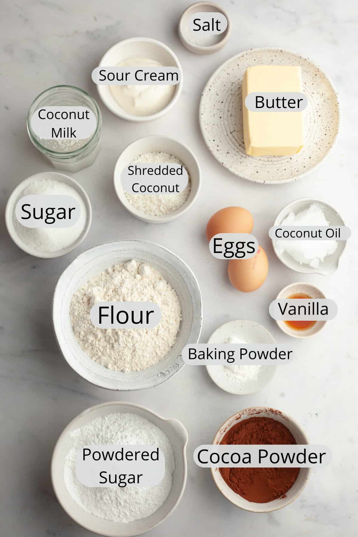 All the ingredients needed to make chocolate coconut cupcakes, weighed out into small bowls.