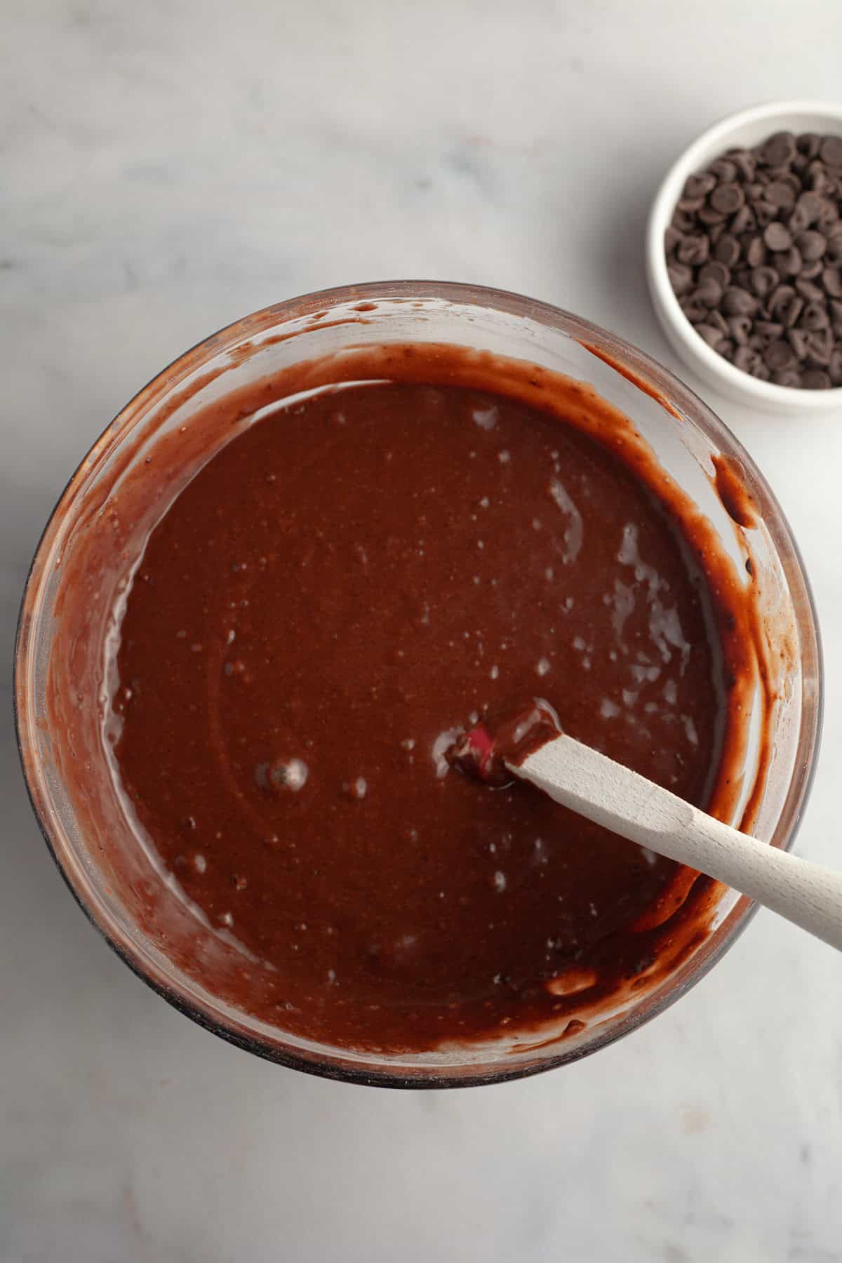 Chocolate muffin batter in a bowl with a whisk.