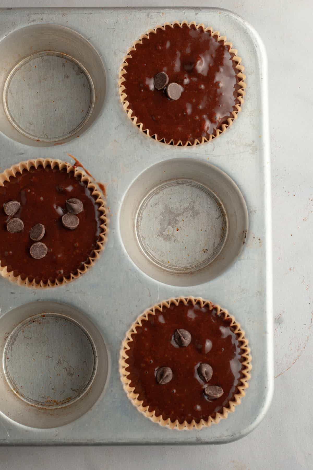 Unbaked chocolate espresso muffins in a muffin pan.