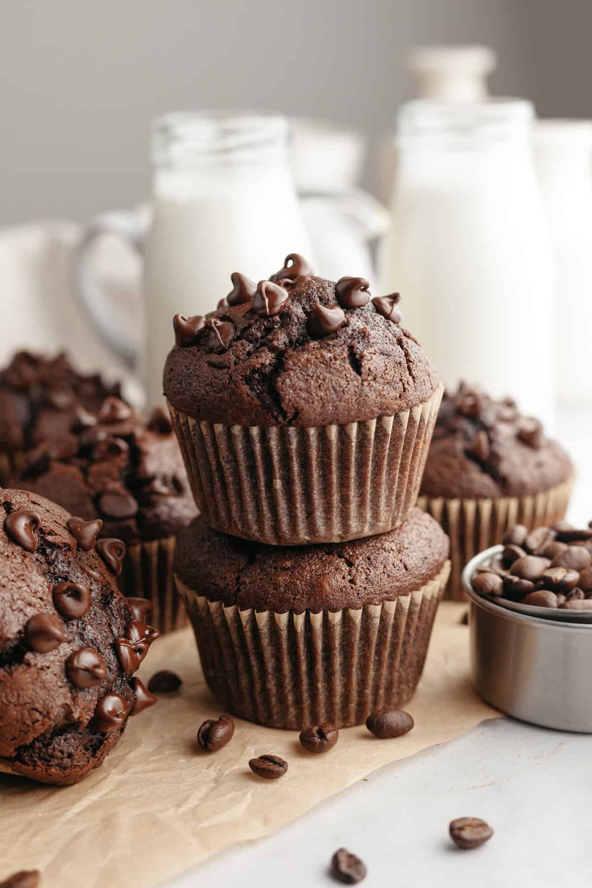 A stack of two double chocolate espresso muffins on brown parchment paper.