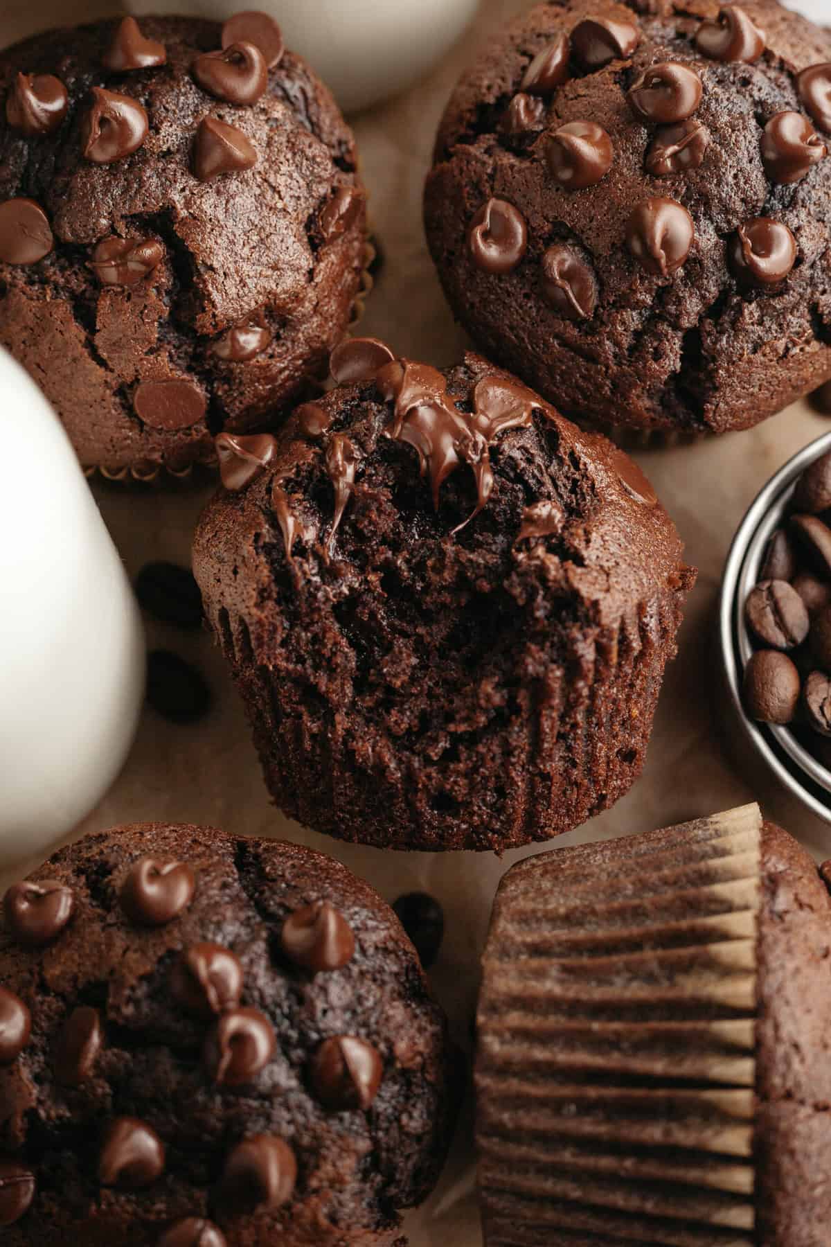 A close up of double chocolate espresso muffins, one has a bite taken out of it.