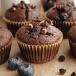 A blueberry chocolate muffin on parchment paper.