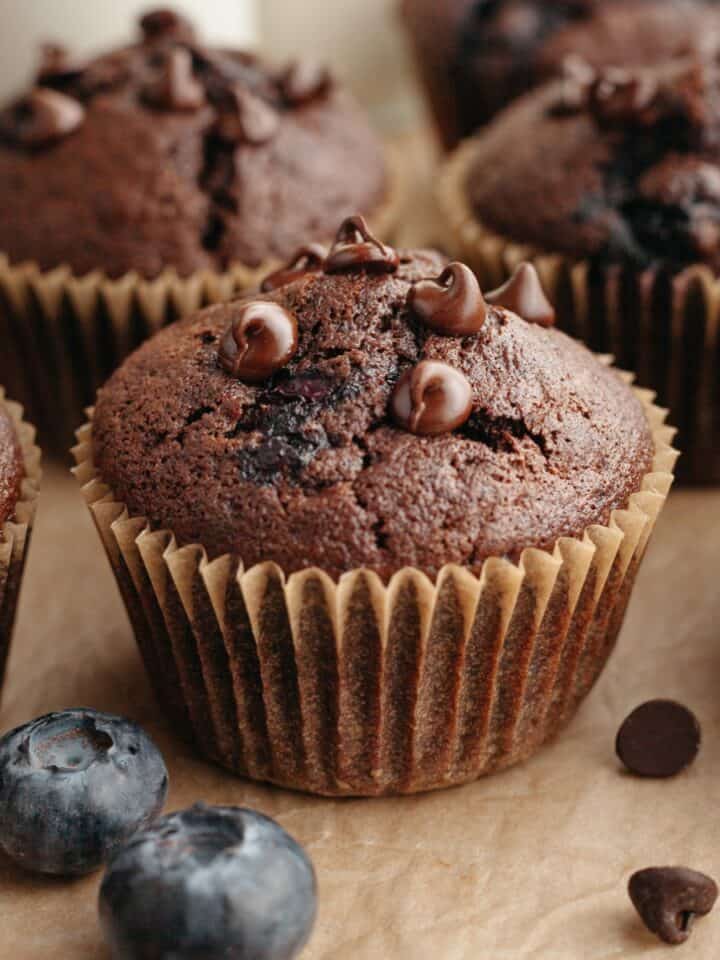 A blueberry chocolate muffin on parchment paper.