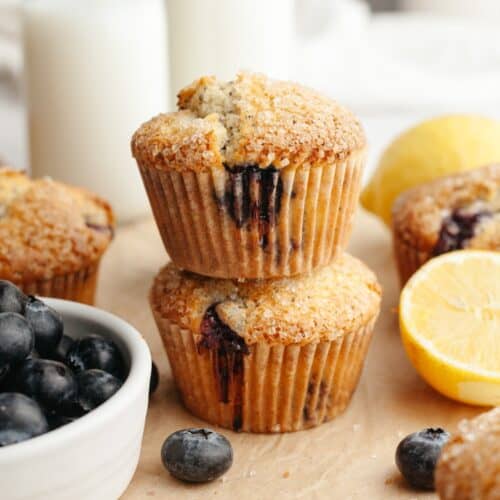 A stack of two lemon blueberry poppy seed muffins on parchment paper.