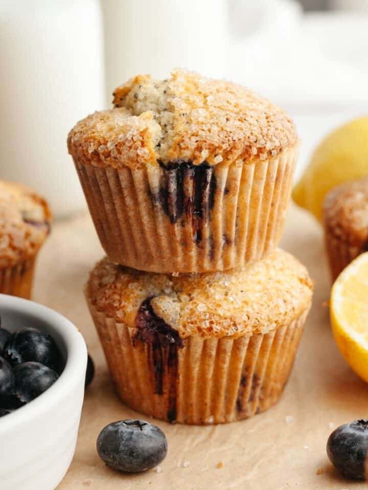 A stack of two lemon blueberry poppy seed muffins on parchment paper.