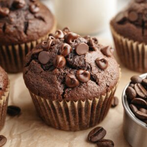 A close up of a double chocolate espresso muffin on brown parchment paper.