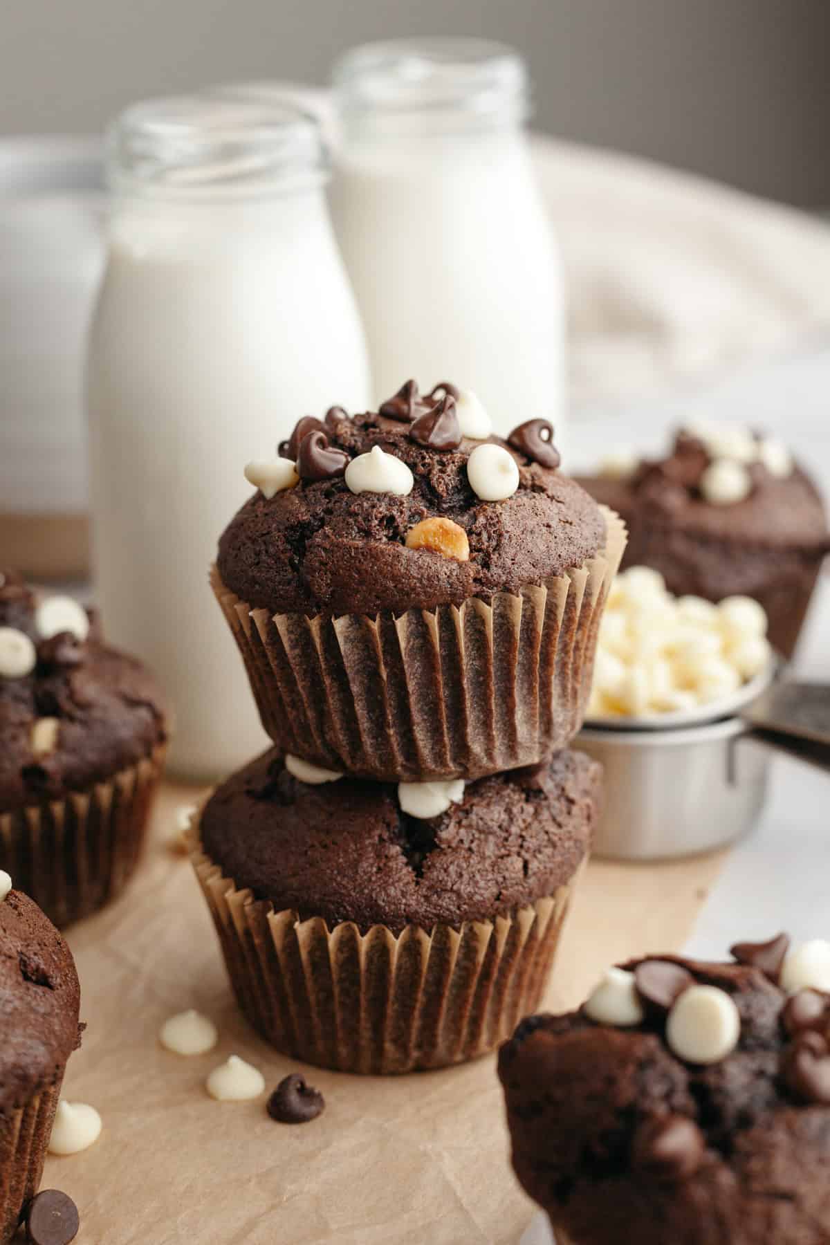 A stack of two triple chocolate muffins on parchment paper.