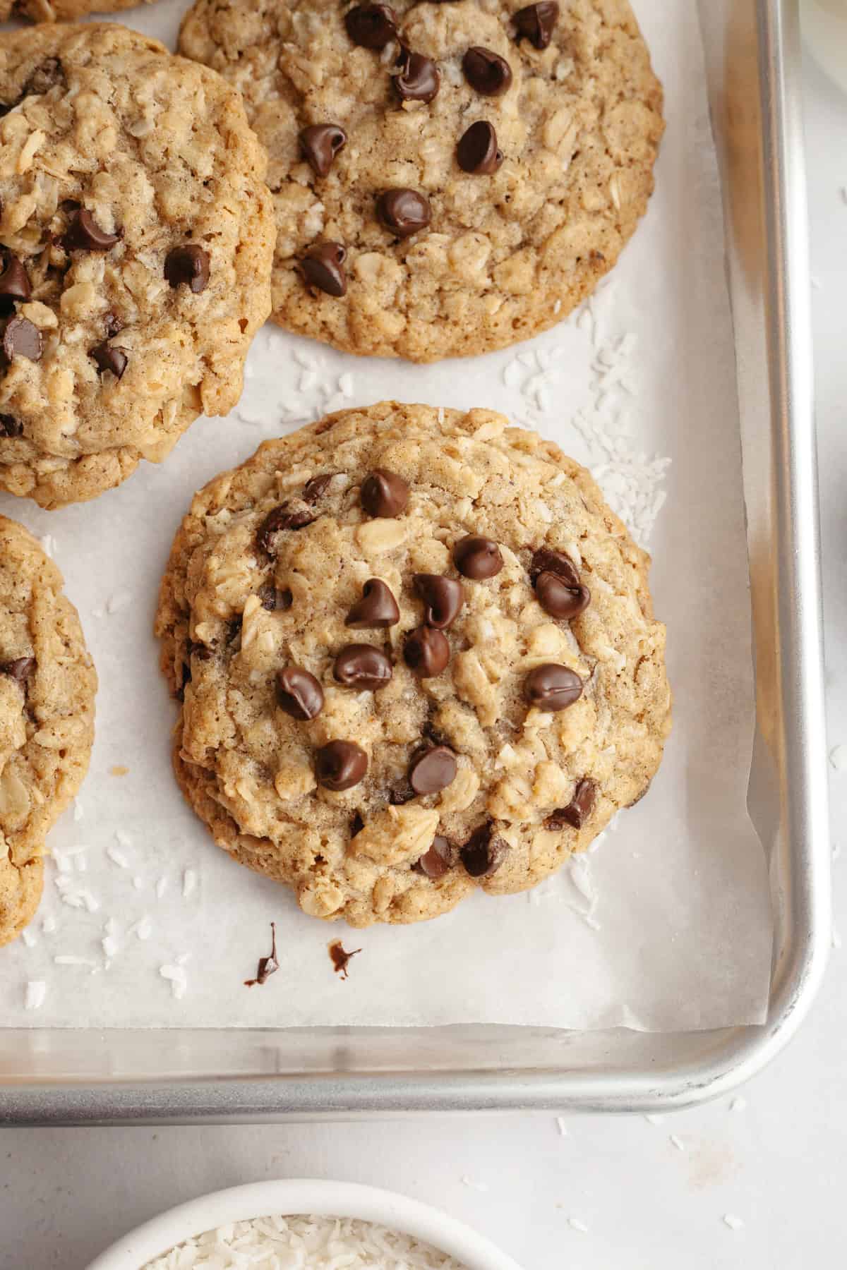 Coconut chocolate chip oatmeal cookies on a baking sheet.