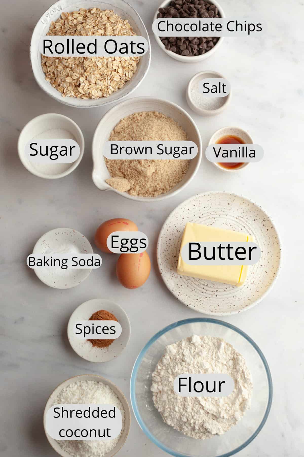 Ingredients needed to make coconut chocolate chip oatmeal cookies, weighed out into small bowls.