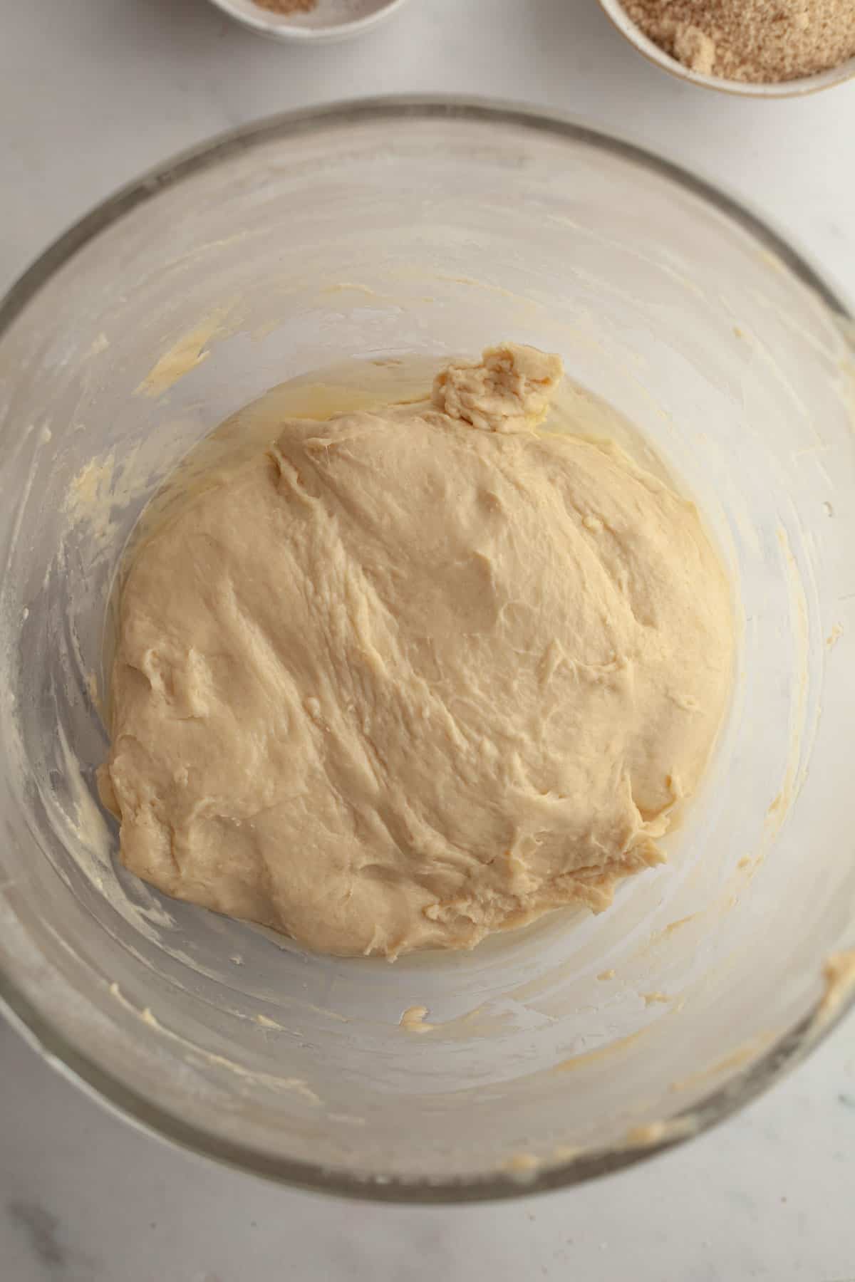 Cinnamon roll dough in a glass bowl.
