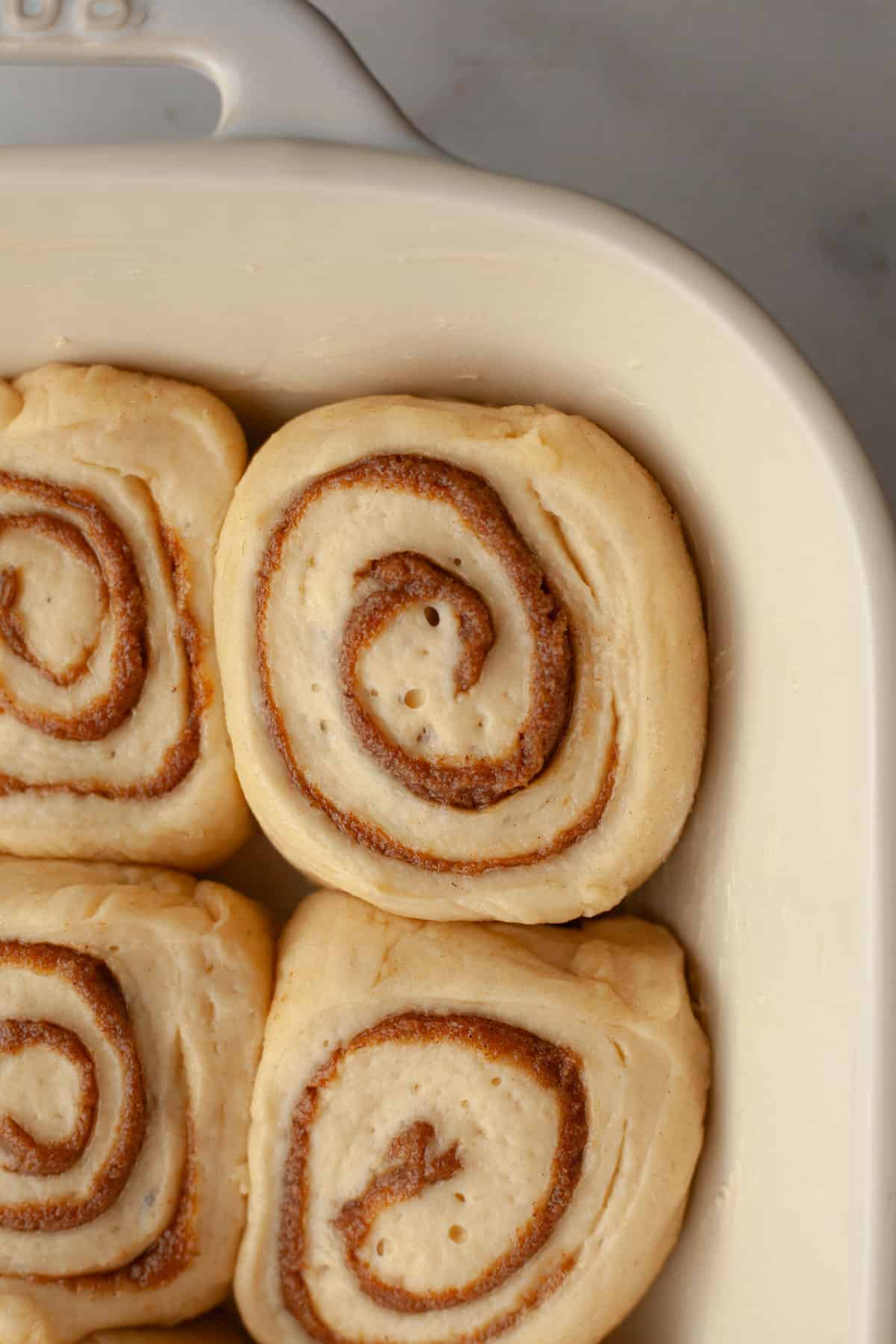 Unbaked cinnamon coffee rolls in a baking dish.