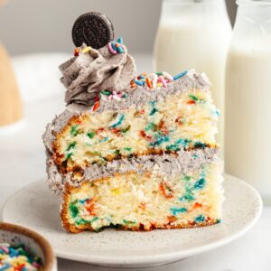 A slice of funfetti Oreo cake on a small plate.