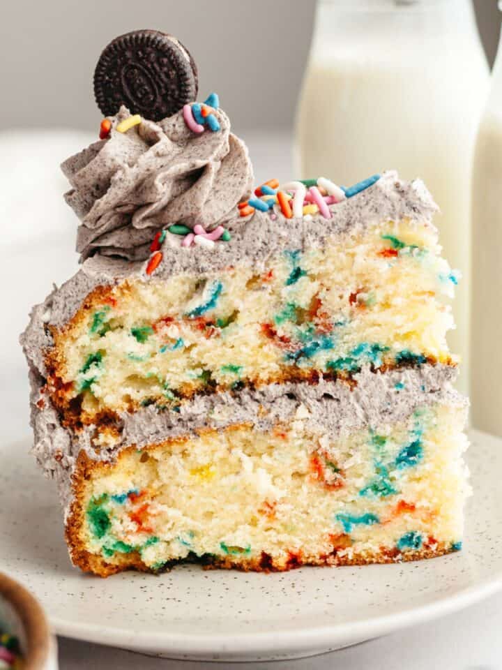 A slice of funfetti Oreo cake on a small plate.