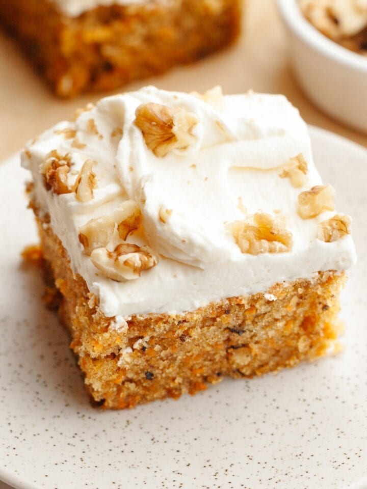 A slice of mini carrot cake with cream cheese frosting and chopped walnuts.