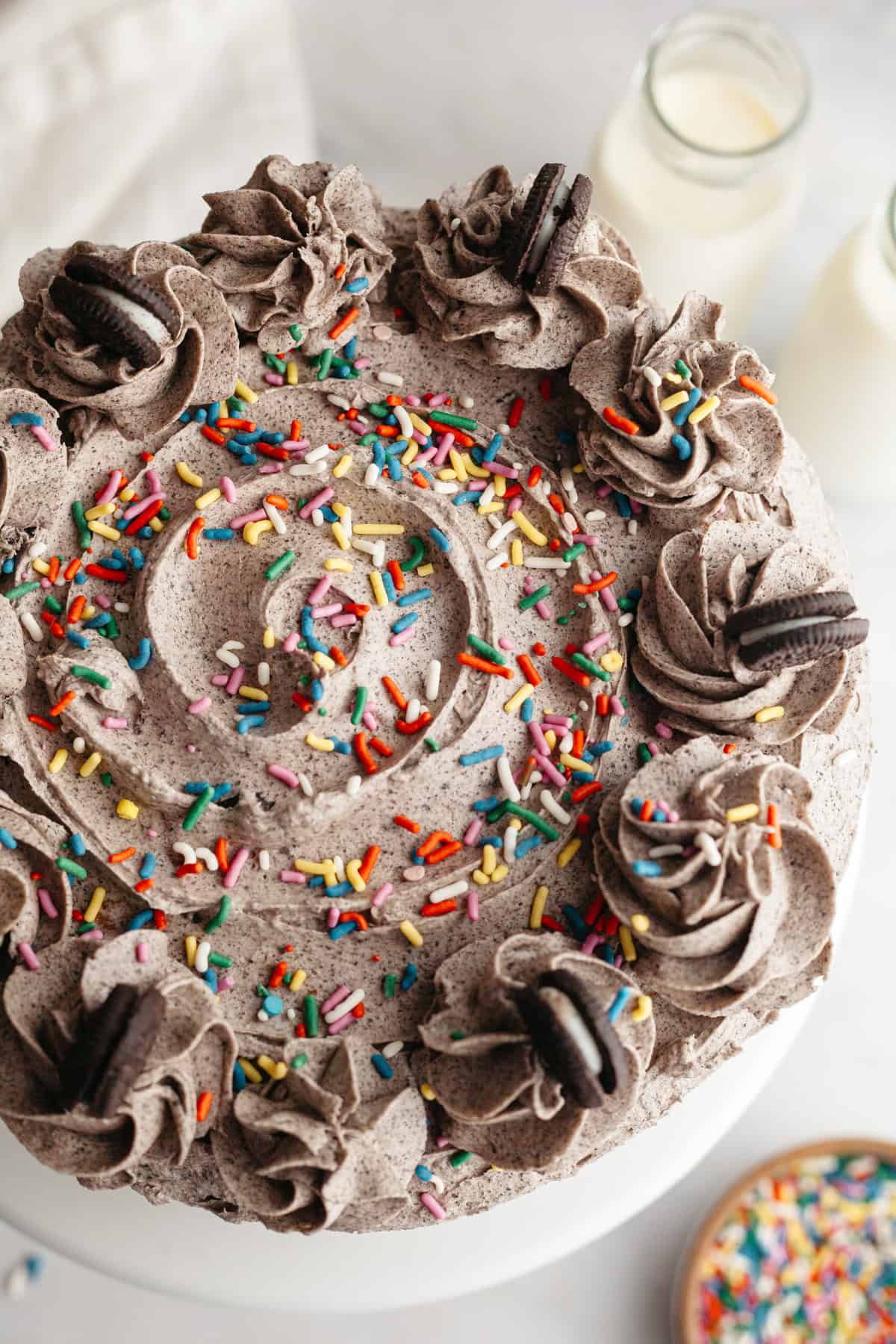 An overhead shot of an Oreo frosted cake with rainbow sprinkles.