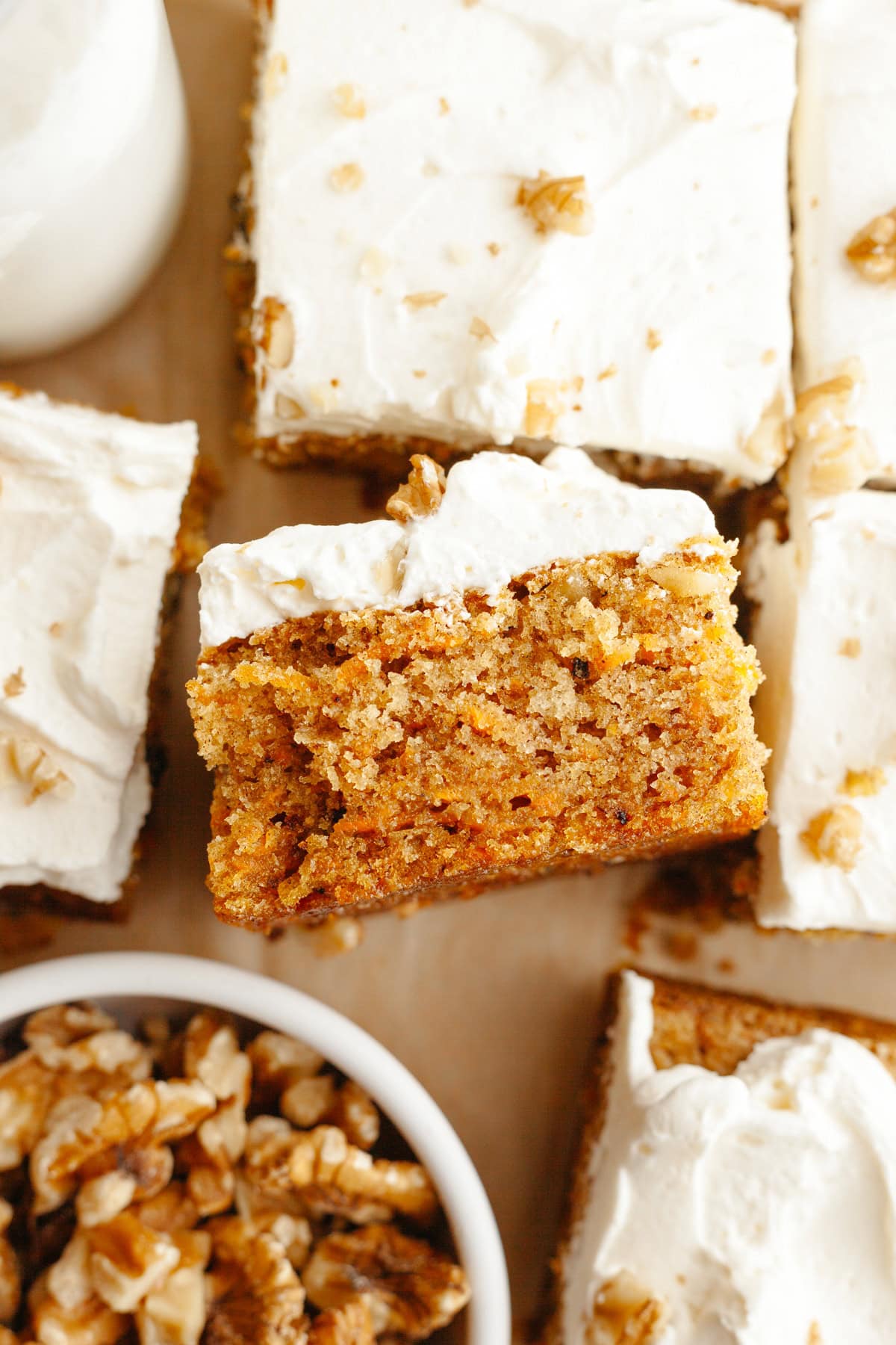 A close up of a square slice of a mini carrot snack cake with cream cheese frosting.
