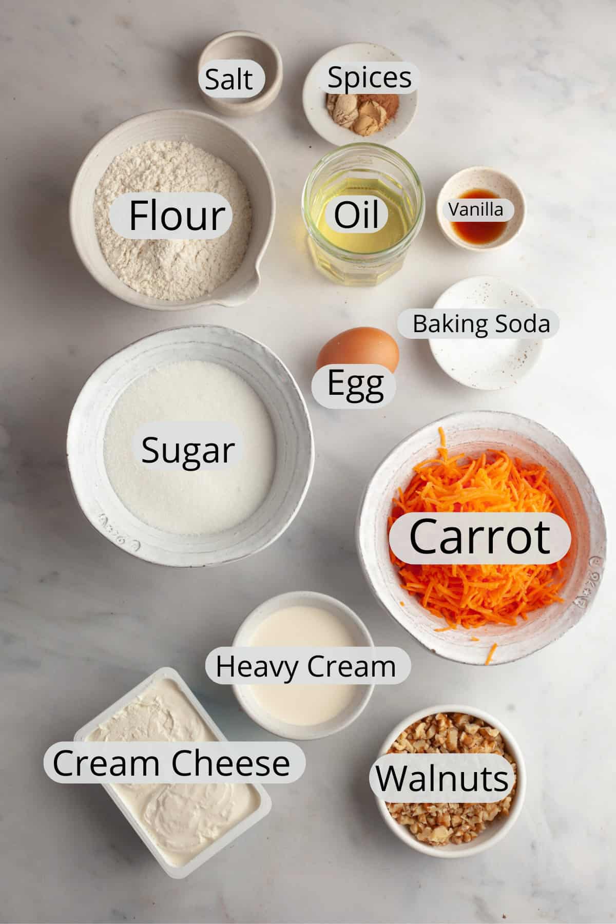 All the ingredients needed to make a mini carrot cake with whipped cream cream cheese frosting weighed out into small bowls.