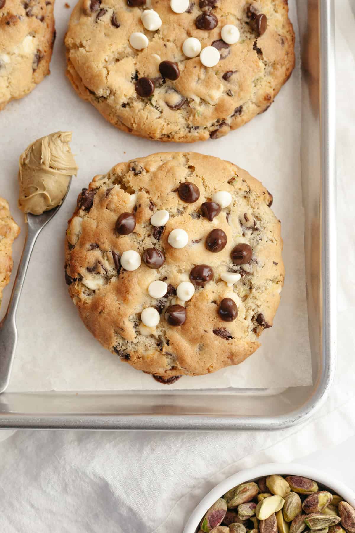 Pistachio and chocolate chip cookies on a baking sheet.