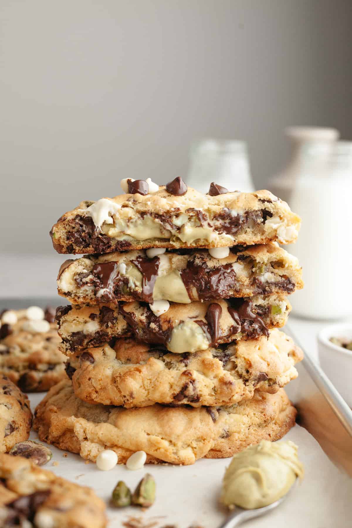 A stack of pistachio cream chocolate chip cookies on parchment paper.