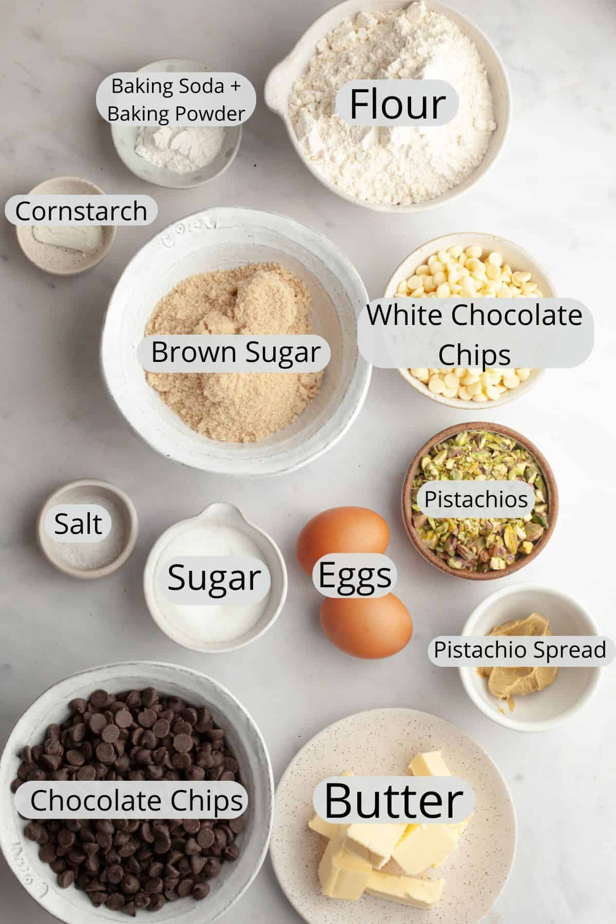 All the ingredients needed to make pistachio chocolate chip cookies, weighed out into small bowls.