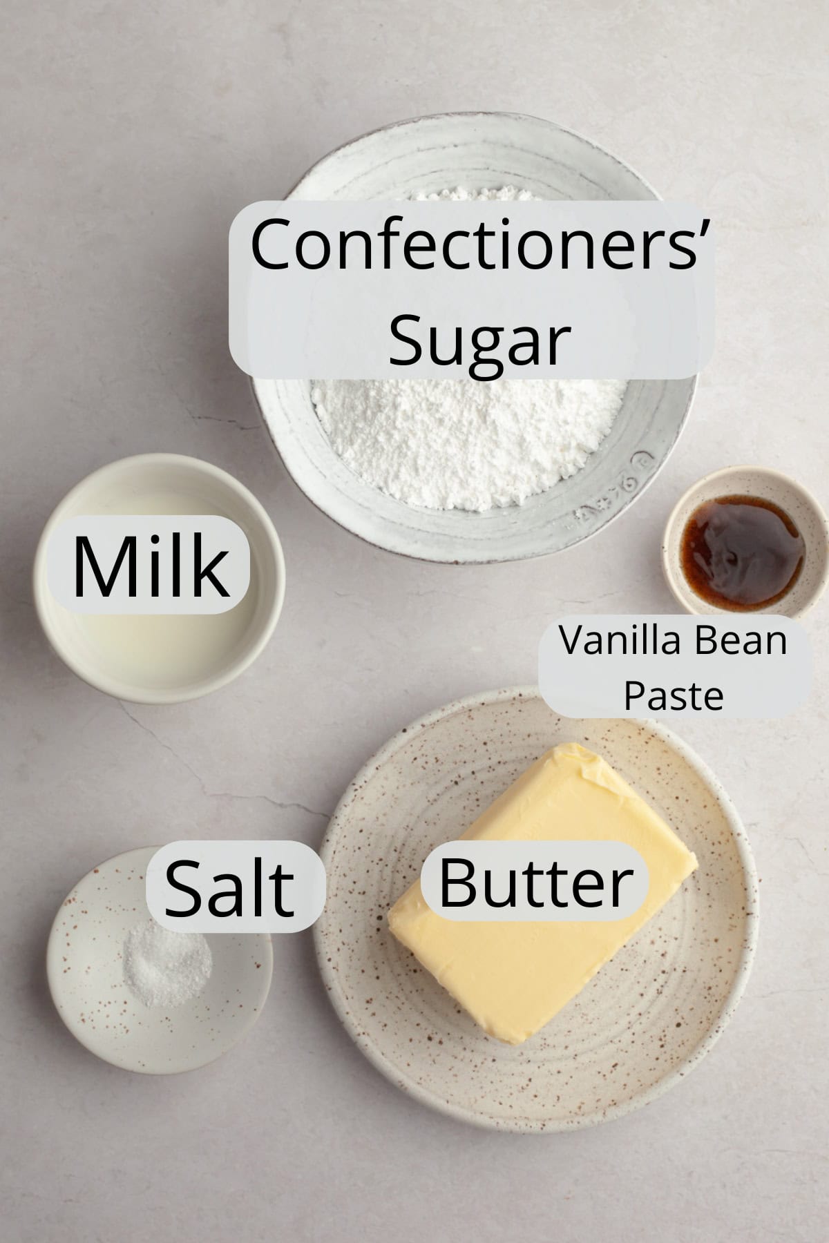 All the ingredients needed to make vanilla bean frosting, weighed out into small bowls.
