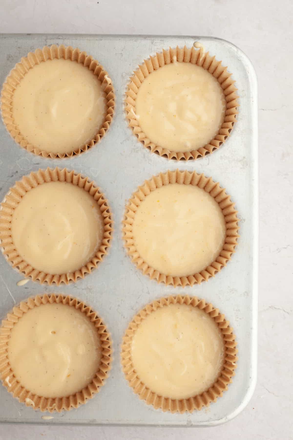 Unbaked vanilla bean cupcakes in a cupcake pan.